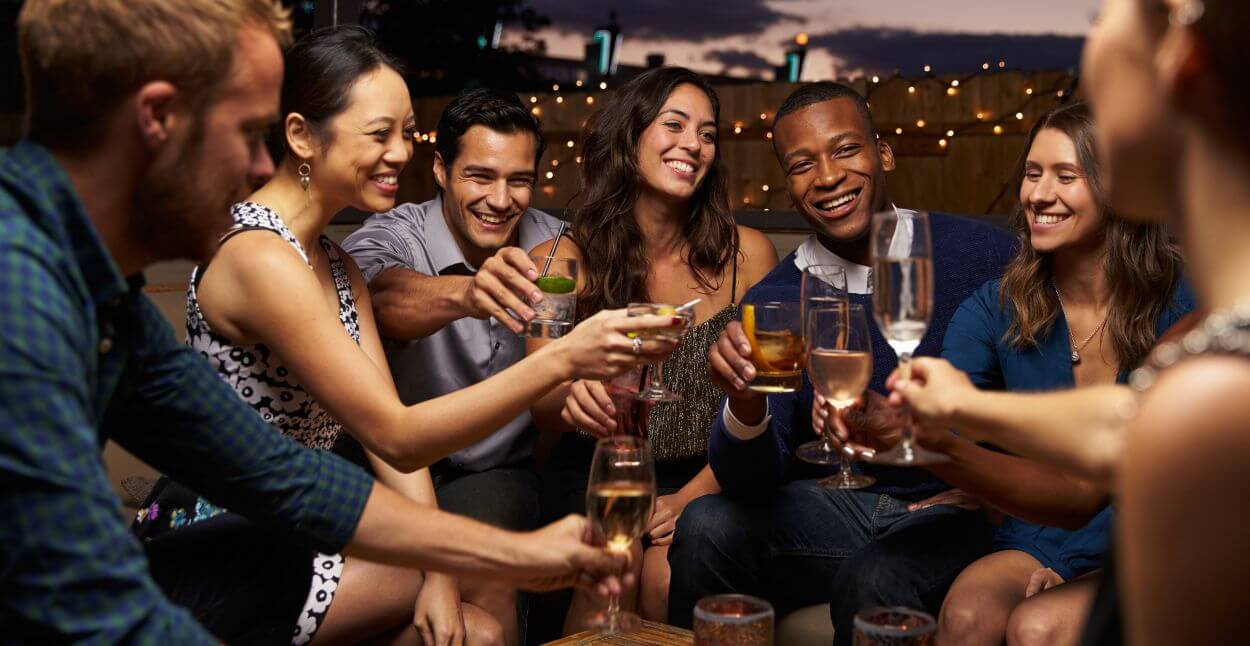 Glade mennesker nyder drinks med inspiration fra Drinksguide
