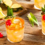 Farverig Mai Tai cocktail med mørk og lys rom i et old fashioned glas med en ananas skive