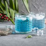 Tropisk Blue Lagoon cocktail med blå curaçao og vodka i et hurricane glas med is